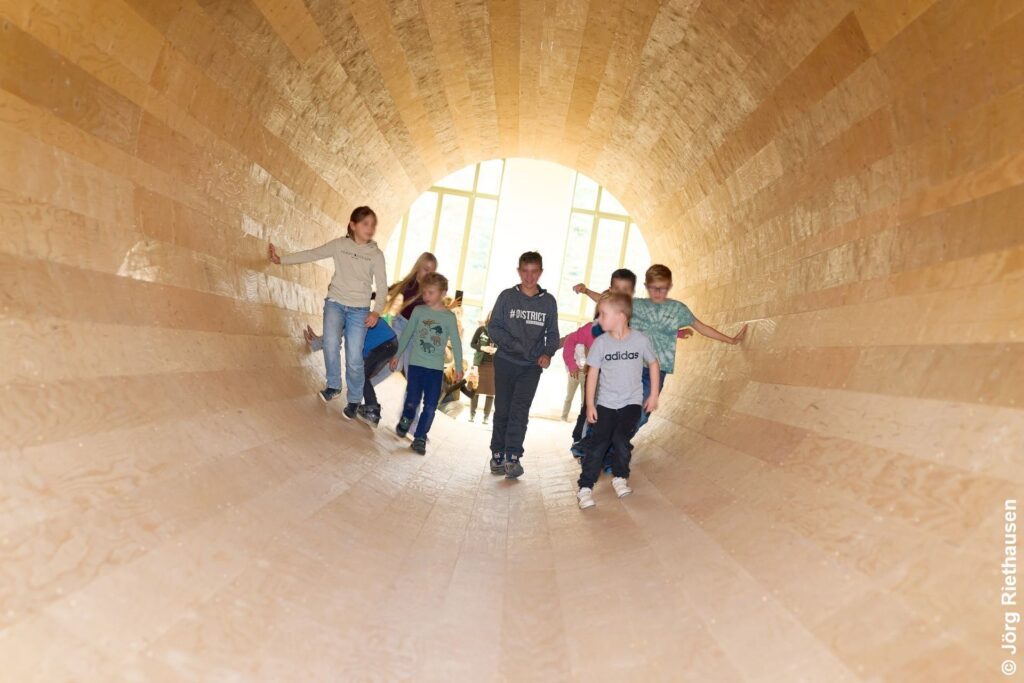 Kinder in der begehbaren Röhre – Alles Holz